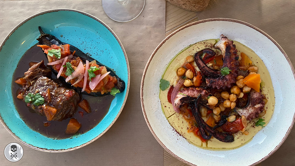 A blue dish with beef and eggplant and a white dish with octopus and chickpeas